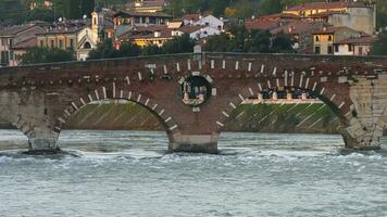 verona, el antiguo romano puente ponte pietra cruce el río adige y ocupado con turistas Veneto video