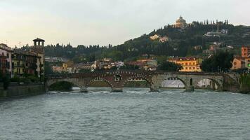 Verona, the old Roman bridge Ponte Pietra crossing the river Adige and busy with tourists. Veneto video