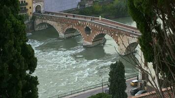 verona, el antiguo romano puente ponte pietra cruce el río adige y ocupado con turistas Veneto video