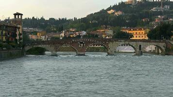 Verona, the old Roman bridge Ponte Pietra crossing the river Adige and busy with tourists. Veneto video