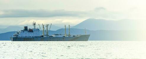 pescar barco de jabeguero en el bahía en el carreteras en Kamchatka península foto