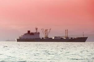 pescar barco de jabeguero en el bahía en el carreteras en Kamchatka península foto