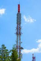 célula torre con antena en contra azul cielo foto