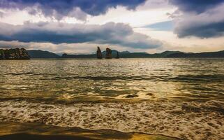 Seascape of Kamchatka Peninsula beautiful view of colorful sunset over Three Brothers Rocks in Avacha Bay on Kamchatka peninsula photo