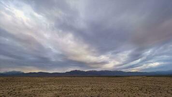 tempo periodo di colorato nuvole nel il sera e deserto con colline su sfondo video