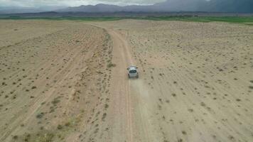 voiture va sur sablonneux terre en friche. désert paysage. aérien voir. drone est Suivant véhicule video