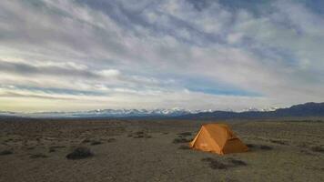 Time Lapse of Touristic Tent, Colorful Clouds in the Morning and Desert with Snowy Mountains on Background video