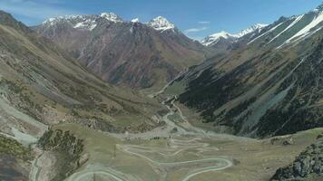 Curvy Serpentine Road Pass in High Mountains. Drone is Flying Forward, Camera is Tilting Down. Establishing Shot video