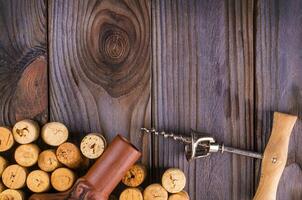 bottle of wine with corks on wooden table background photo