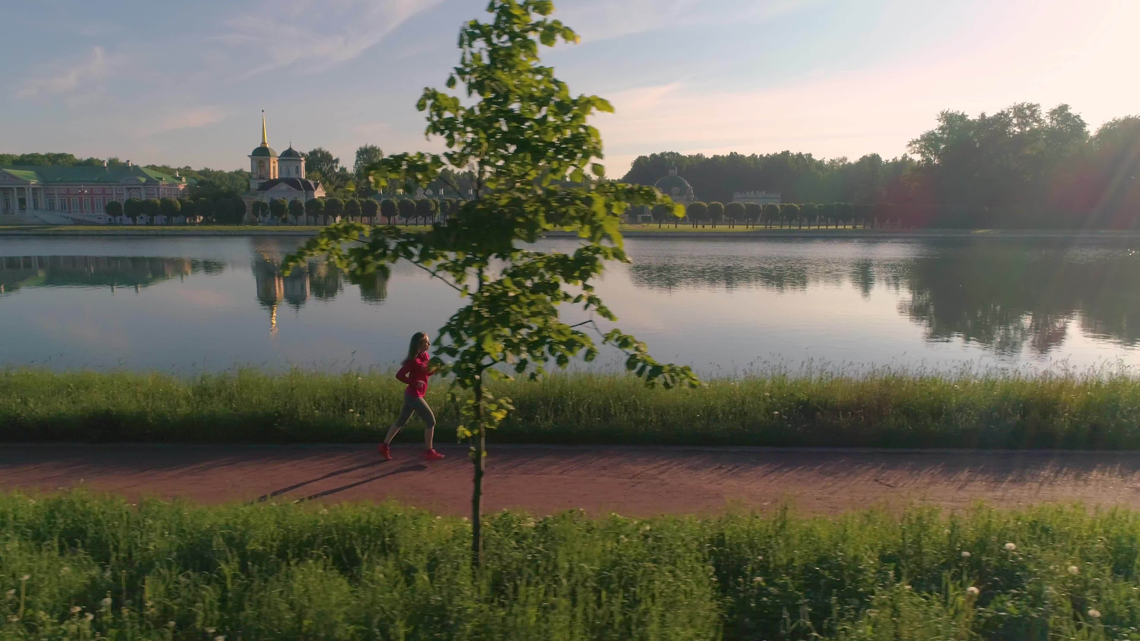 jung gesund Frau Joggen im schön Park mit Teich im das sonnig