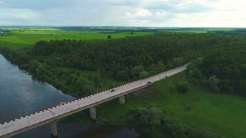 Car going on bridge over the river. Green field and forest. Aerial view. video