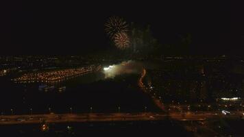 Fireworks in the city. River with bridge. Drone is flying back. Aerial view. video