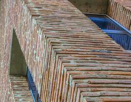 Angled view on modern red clinker brick facade wall of residential building house photo