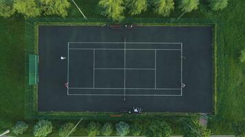 Giocatori giocare tennis su un' verde Tribunale. aereo superiore Visualizza. video