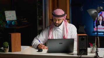 homem às casa pagando atenção dentro elearning seminário teleconferência com professor, escrevendo memorando para lembrar mais tarde. Educação escolar em casa aluna ouvindo para lição enquanto levando Nota do final de semana dever de casa video