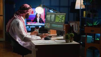 Cinematographer in home office doing post production on upcoming movie release, editing footage and sound. Man using computer workstation after being comissioned to modify film video