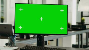 Greenscreen computer display on desktop, empty small business office. Isolated mockup template shown on modern monitor screen, blank copyspace with chromakey technology, digital software. video