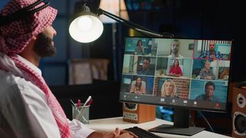 Arab man paying attention in webinar internet teleconference. Middle Eastern student in online videocall with tutor and other diverse multiethnic colleagues, listening to lesson video