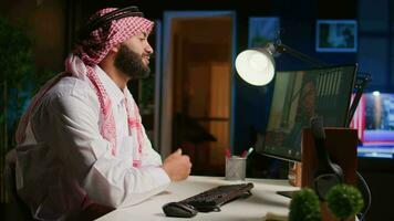 Muslim worker in video call session with therapist, asking for advice, feeling down. Remotely working Middle Eastern employee in internet consultation with psychologist from stylish cozy home