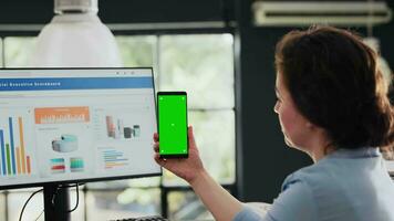 Manager holding phone with greenscreen in coworking space business headquarters, looking at mobile device with blank mockup screen. Specialist checking isolated copyspace layout. Handheld shot. video