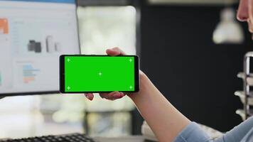 Analyst examines greenscreen software while she holds smartphone, isolated copyspace template shown on screen. Specialist checking blank mockup layout on mobile device. Handheld shot. Close up. video