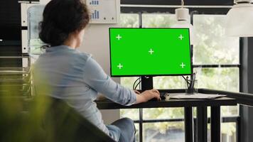 especialista relógios tela verde Área de Trabalho sentado às escritório mesa, verificação em branco chromakey exibição em monitor. mulher digitando em formação e olhando às isolado brincar disposição em computador. video