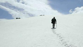 Bergsteiger Mann geht auf Schnee im das Berge mit Eis Axt. video