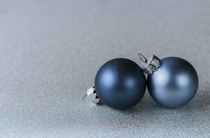 two blue Christmas balls on a shiny silver background. Christmas composition photo