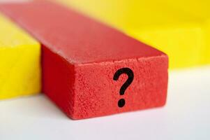 Question mark on red wooden block. Question and answer session. photo