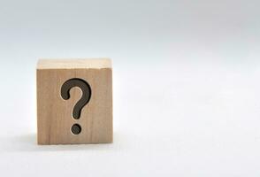 Question mark on wooden cube on white background. Question and answer concept. photo