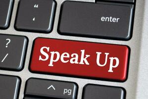 Speak up text on red color laptop keyboard. Courage to speak up concept. photo