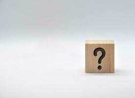 Question mark on wooden cube on white background. photo