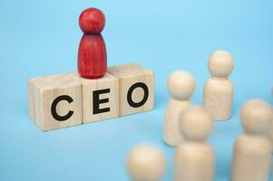 Red figure on top of wooden cubes with CEO text. Leadership concept photo