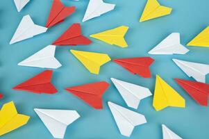 amarillo papel avión origami líder otro blanco papel aviones en azul antecedentes. liderazgo concepto. origami concepto. foto