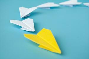 Side view of yellow paper airplane origami leading white paper airplanes. Leadership and copy space concept photo