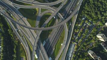 Multi-level road interchange and cars traffic. Drone is spinning around at high altitude. Aerial vertical shot. video