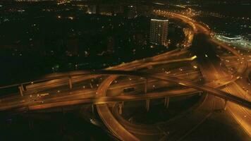 zumbido es volador a lo largo iluminado complejo intercambio. carros tráfico a noche. aéreo vista. video