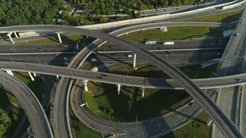 Multi-level road interchange and cars traffic. Drone is flying forward, camera is tilting down. Aerial view. video