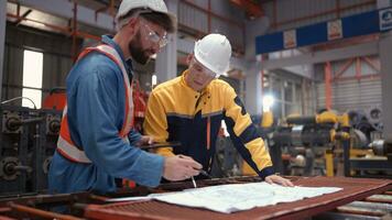 Team of engineers and architects working with blueprint at factory site. It is a massive new facility for making metal sheets as well as a transportation and distribution warehouse. photo