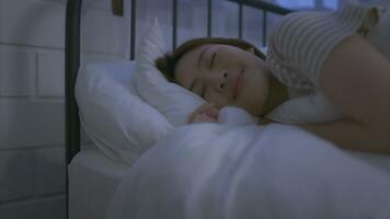 Asian young woman turn off the bedside light and then her sleep on a soft pillow photo