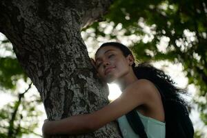 Portrait of a beautiful young woman with backpack standing and forest bathing photo