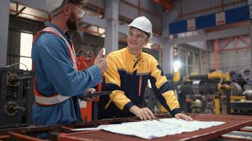 Team of engineers and architects working with blueprint at factory site. It is a massive new facility for making metal sheets as well as a transportation and distribution warehouse. photo