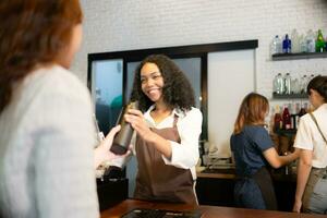 Young woman barista serves customers who bring their own cups in a coffee shop. photo