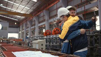 Team of engineers and architects working with blueprint at factory site. It is a massive new facility for making metal sheets as well as a transportation and distribution warehouse. photo