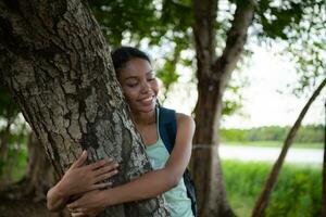 Portrait of a beautiful young woman with backpack standing and forest bathing photo