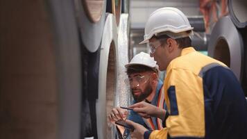 un equipo de joven hombres trabajando en un almacén almacenamiento rollos de metal hojas. inspeccionando el metal sábana rollos almacenado en el almacén a ser importado sobre el metal sábana producción línea. foto