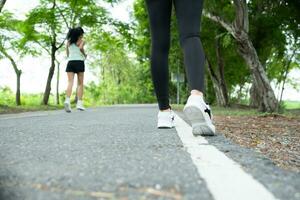 corredor atleta corriendo en la carretera en parque. mujer aptitud trotar rutina de ejercicio bienestar concepto. foto