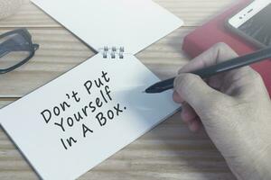 Motivational quote on notepad. Do not put yourself in a box. photo