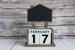 Chalkboard with date on white cube block on wooden table. photo