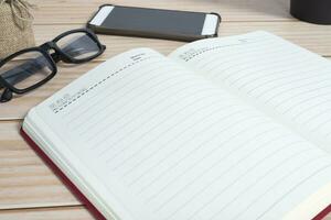 View of office desk with smartphone, reading glasses and and notepad. photo